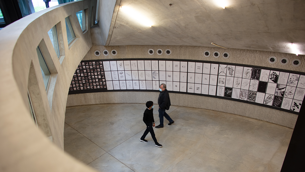 Two people walking through an architectural review gallery.
