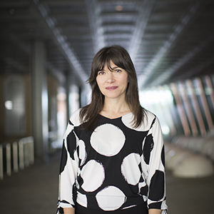 a person standing in a building corridor wearing a black shirt with large white dots