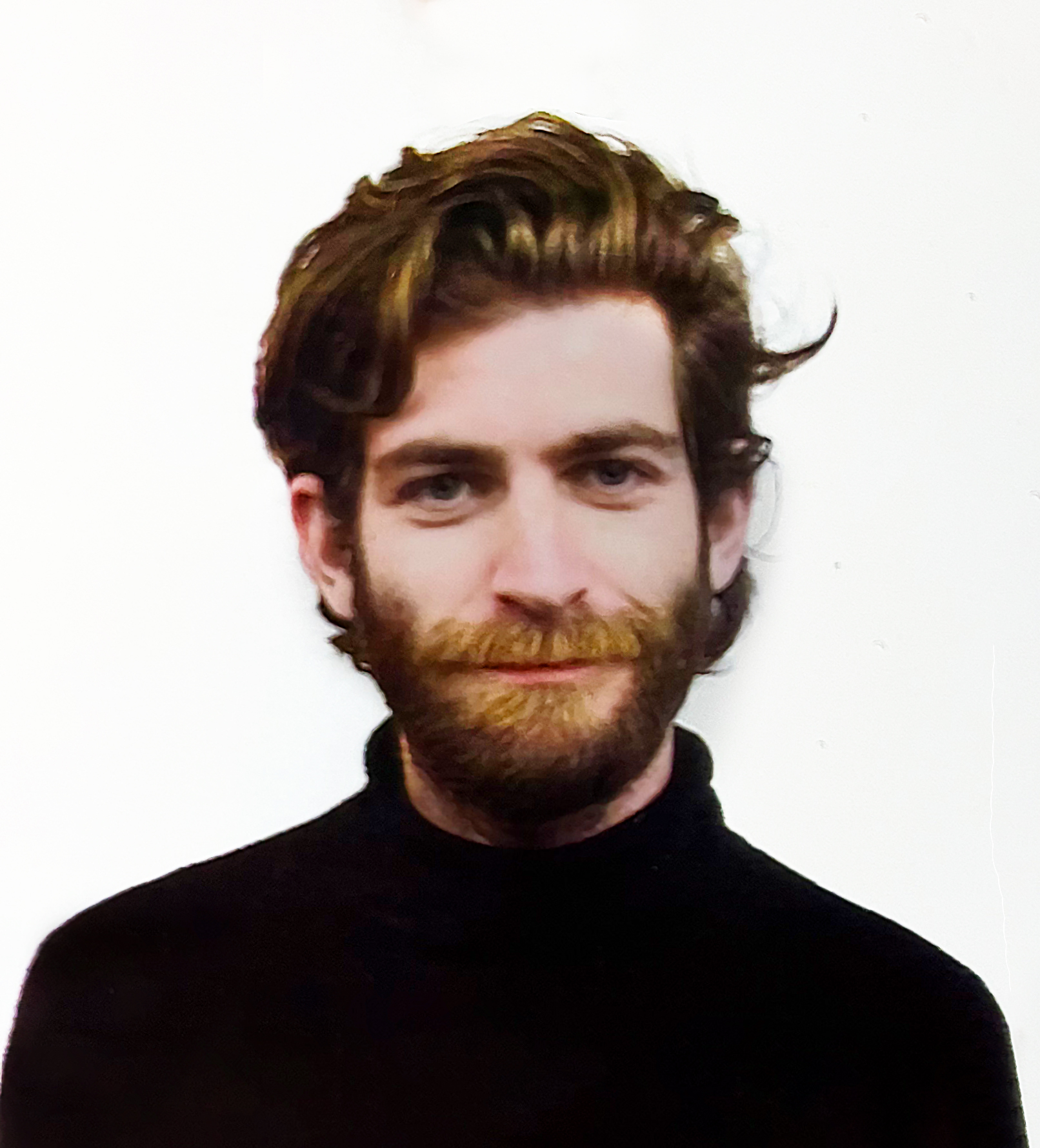 A person with short hair wearing a black turtleneck standing in front of a white background.