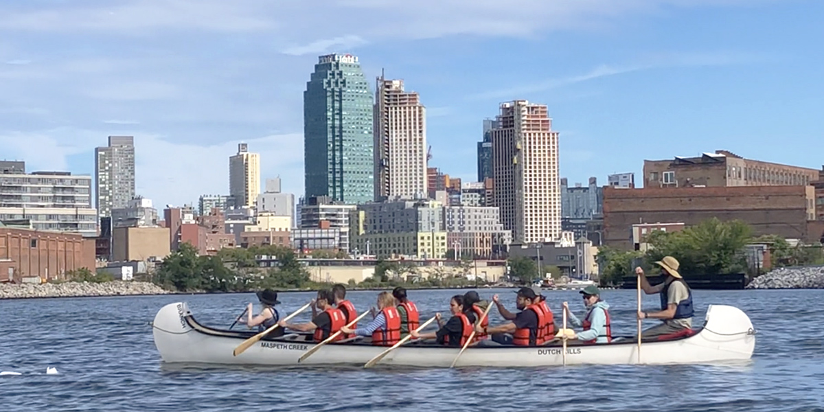 people in a canoe with a skyline in background
