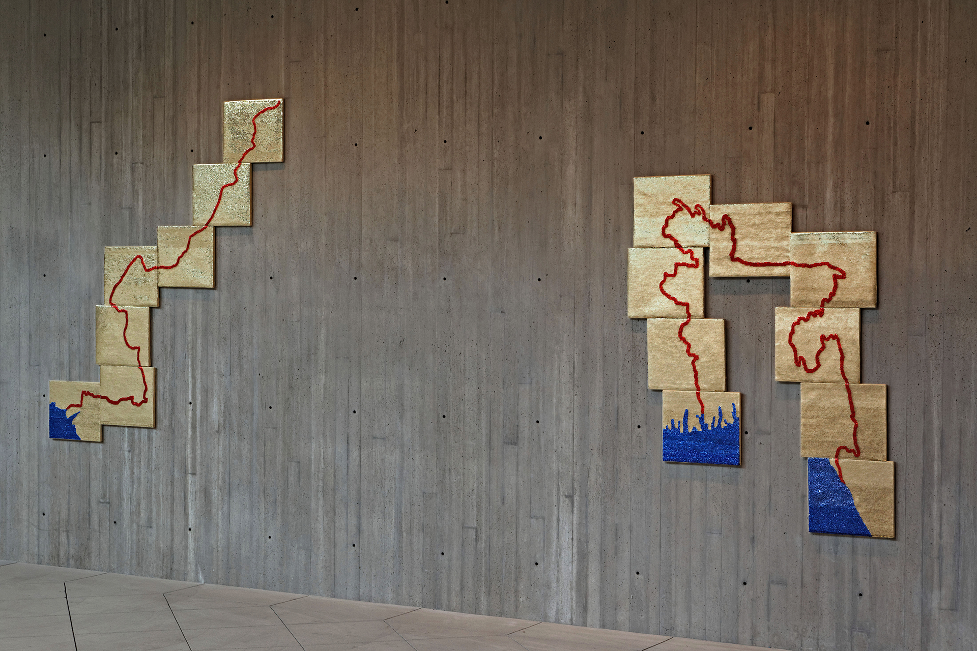Art gallery display of gold squares connected by a red line.