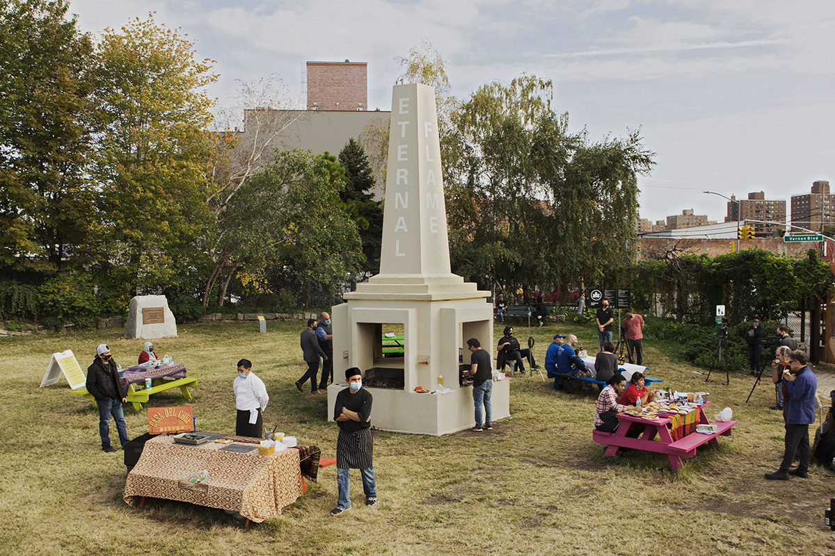 a public park space with obelisk at center and people around