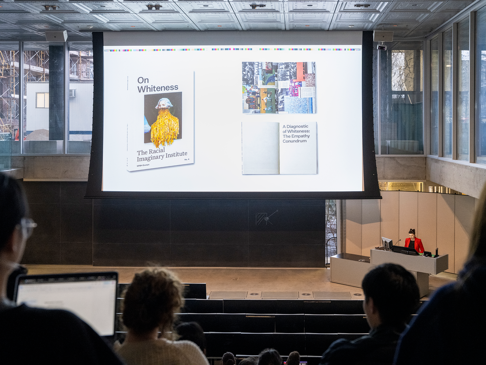 Person delivering a lecture in front of a large screen