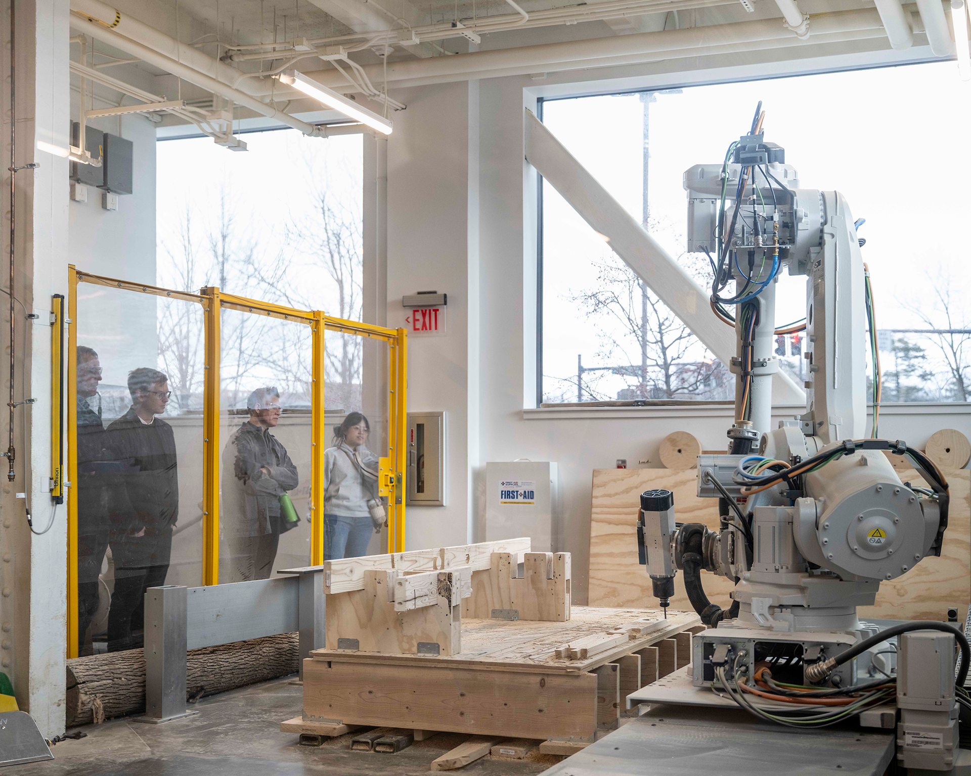 People observing a robotic arm