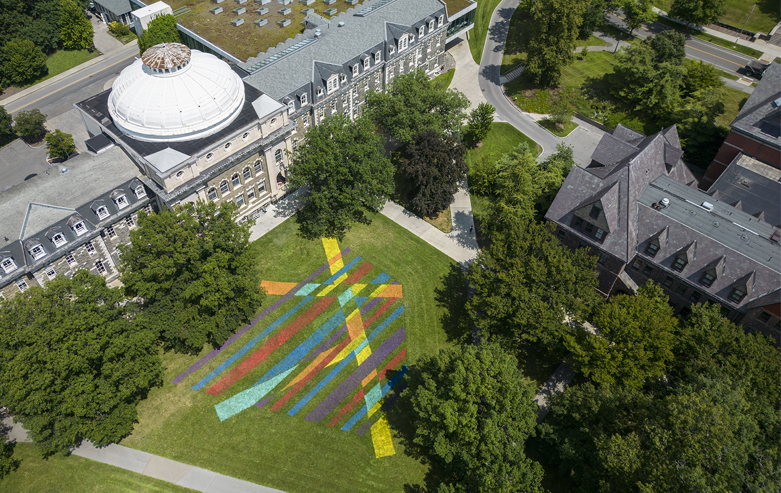 Aerial view of brightly painted geometric design on green grass