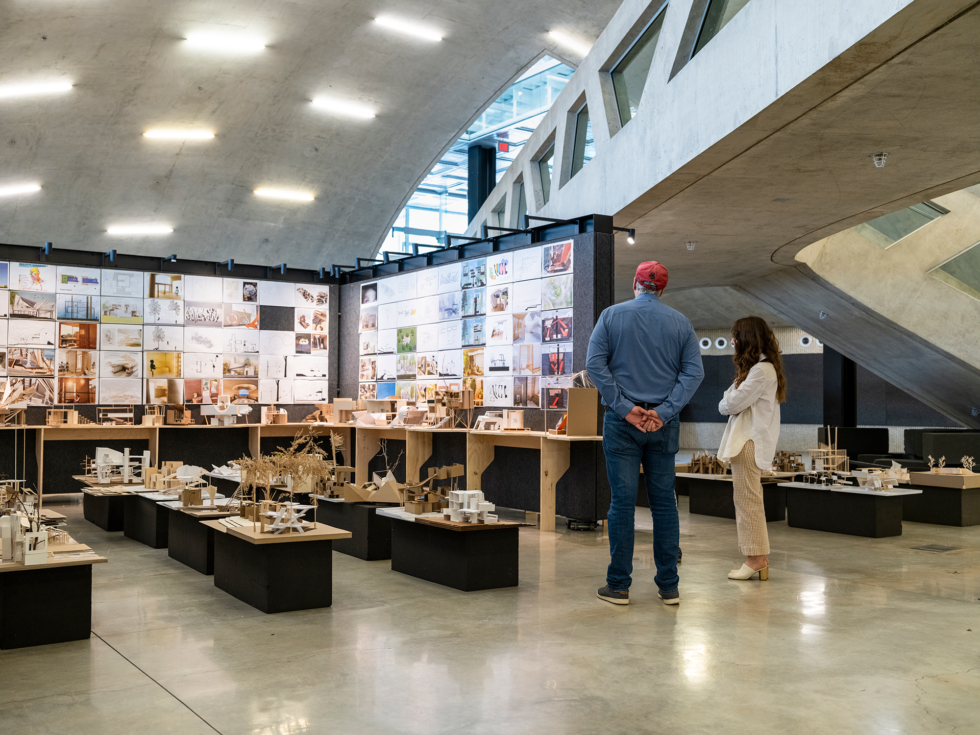 People visiting an exhibition of architectural models and posters