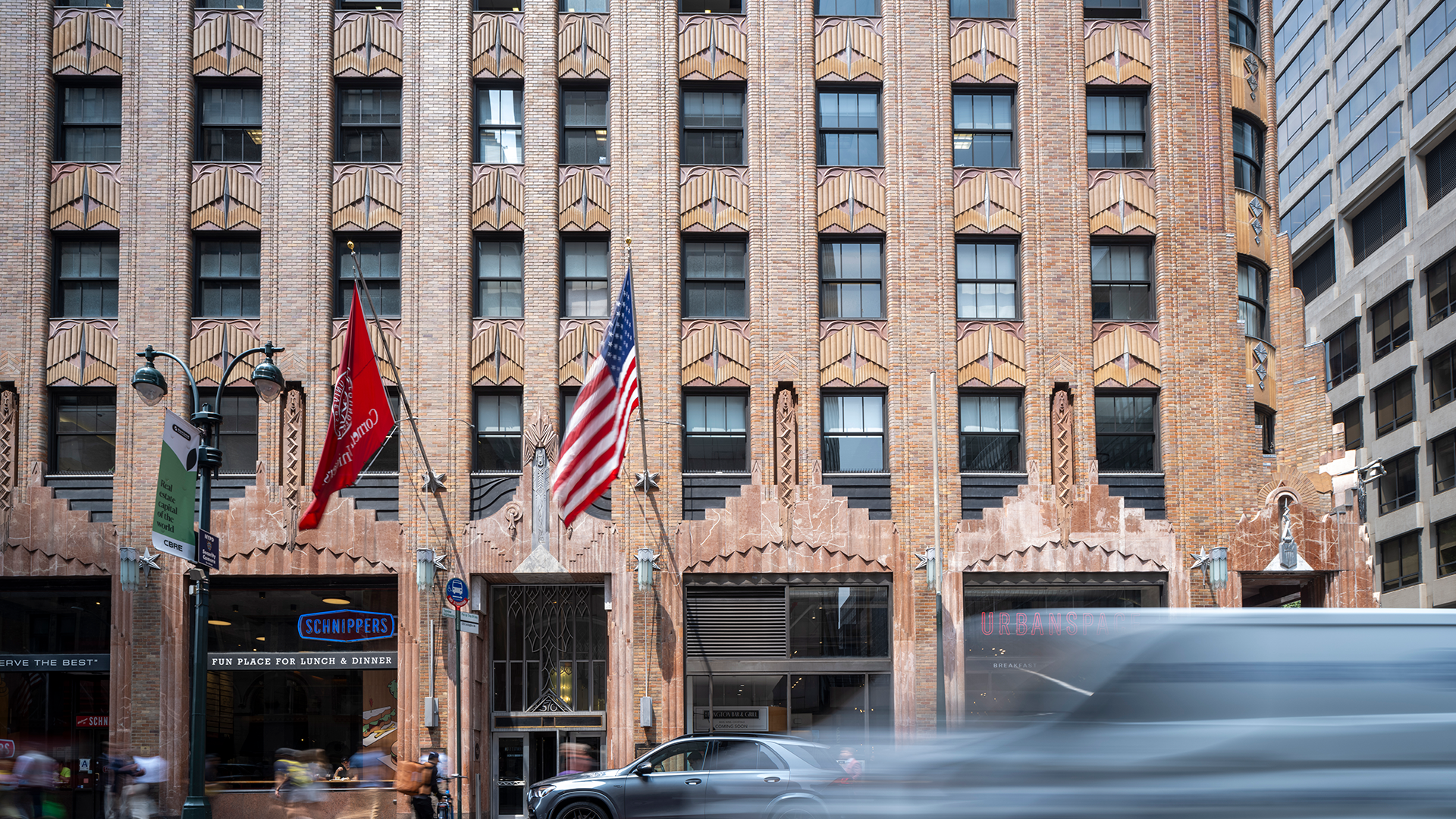 New York City street with brick building and passing vehicles