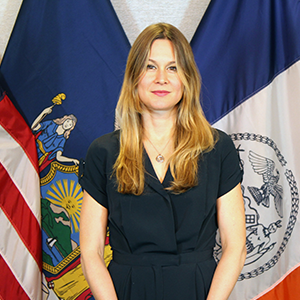 A woman with long hair faces the camera