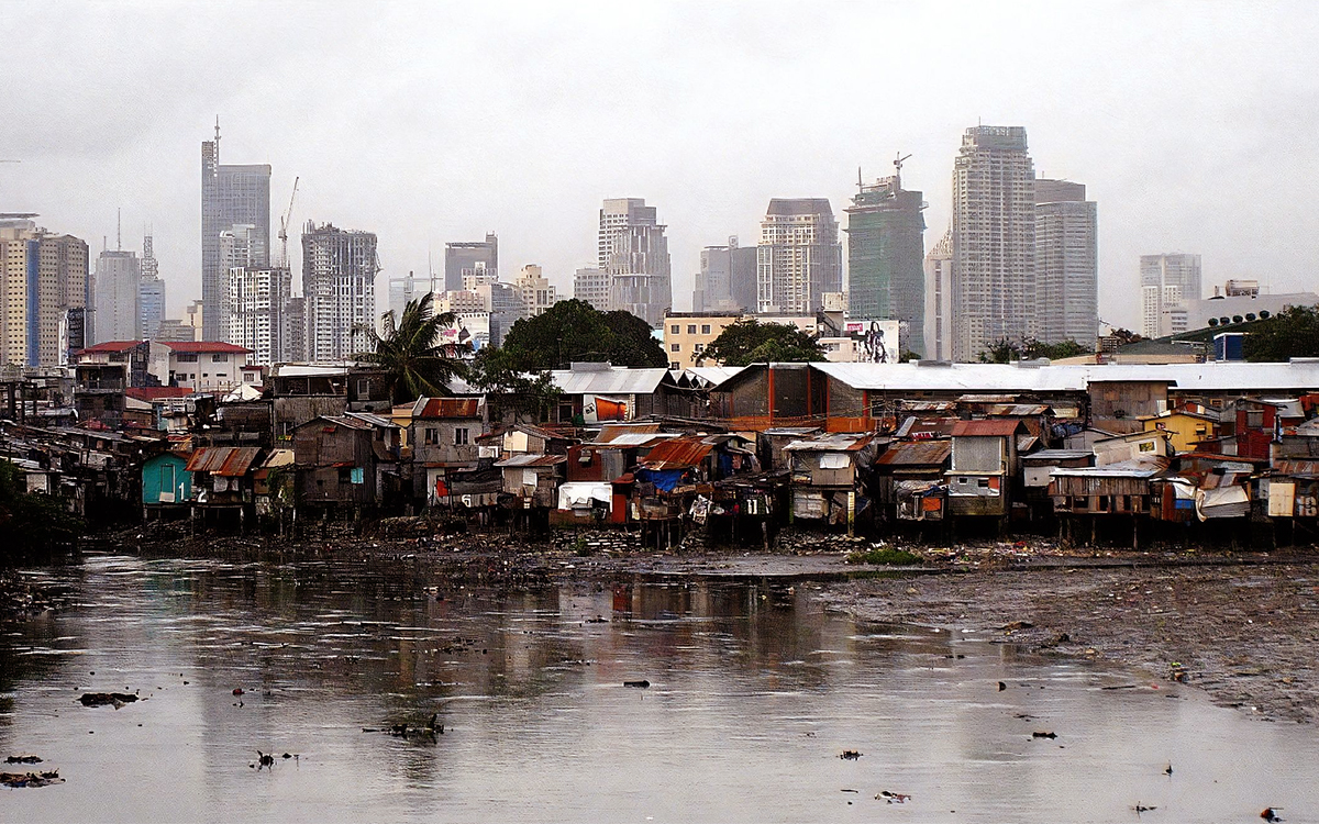 Manila city scape with informal housing and flood water in foreground