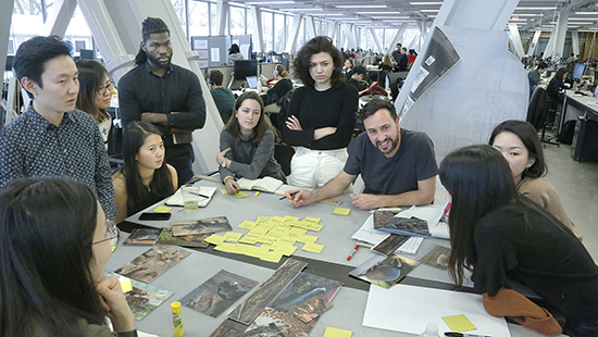group of students and faculty engaged in discussion in an architecture studio