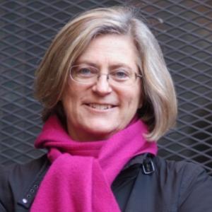 white woman with blond grey hair and pink scarf