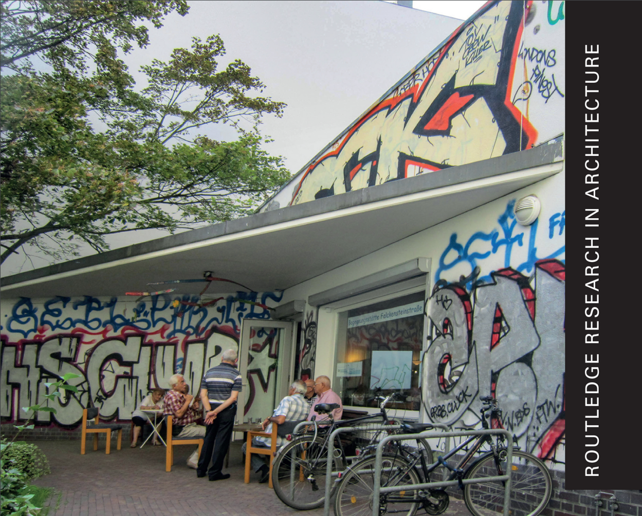 Men and bikes outside a graffiti covered building