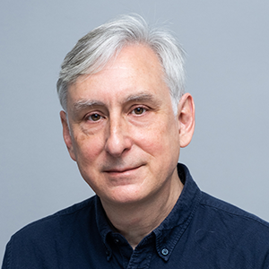 a man with a blue collared shirt and grey hair