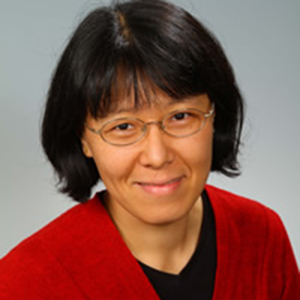 A woman with short dark hair wearing glasses.