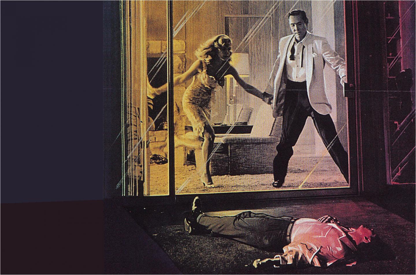 A woman grabbing the hand of a man standing in front of a sliding glass door with another man laying on the ground on the other side who appears to be dead.