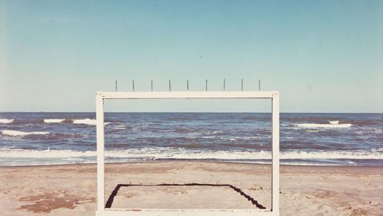 A wooden frame with spikes on top installed on a beach