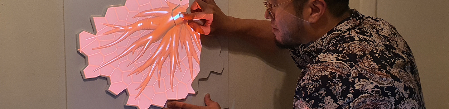 A person interacting with a projected 3d image on a wall.