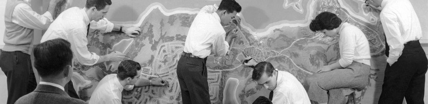 People working together on a large scale map.