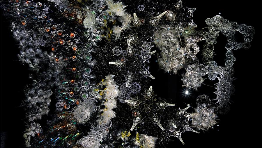 Upwards view of an installation composed of numerous structures of diferent sizes, shapes and colors - the entire combination resembling a an starry night sky.