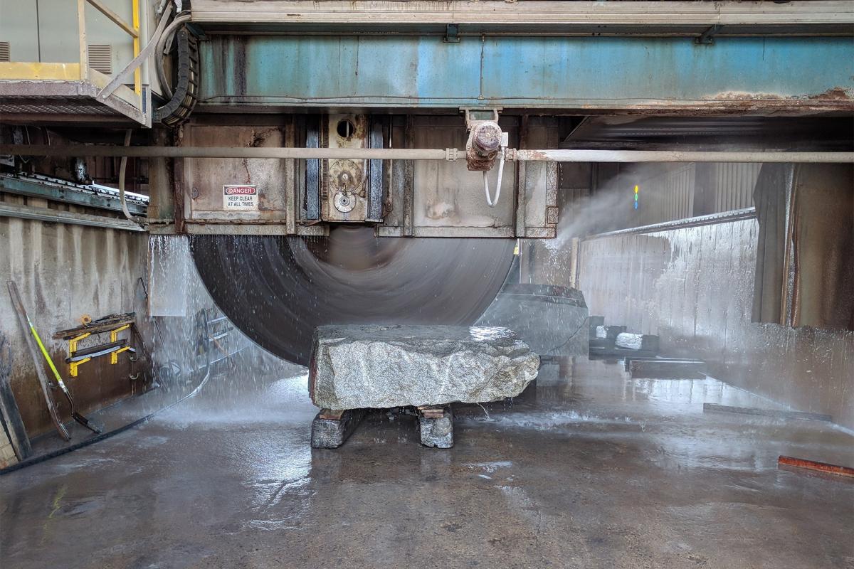 A large wet saw cutting into a piece of stone.
