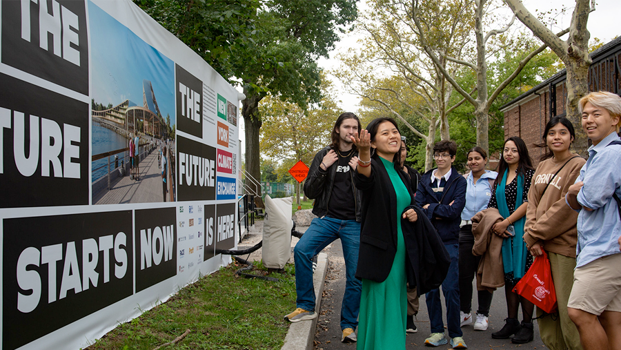 A group of people standing in front of a sign the reads 