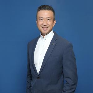 a man wearing a white shirt with a blue dress jacket in front of a bright blue background