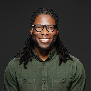 Smiling man with a green button up shirt wearing glasses