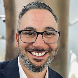 Man smiling with eyeglasses and a beard