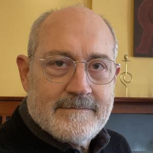 man with short great hair and beard, glasses and black and great shirts