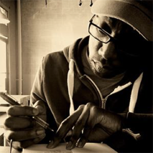 sepia tone photo of a man in a hat and glasses writing