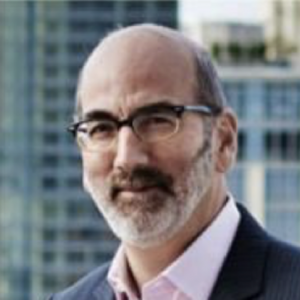 man with glasses and pink shirt and dark jacket