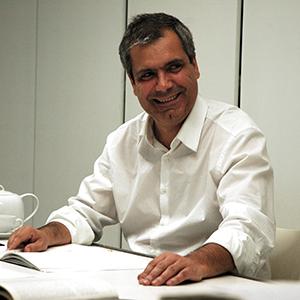 a man in a white shirt seated at a work table