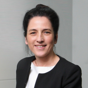 A woman with dark hair worn up smiling at the camera