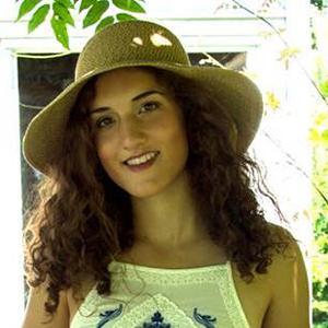 Portrait of a person in a hat with long curly hair