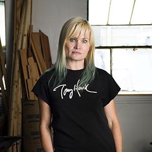 headshot of a woman with blond hair wearing a black t-shirt