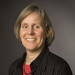 A person in a black jacket and red shirt