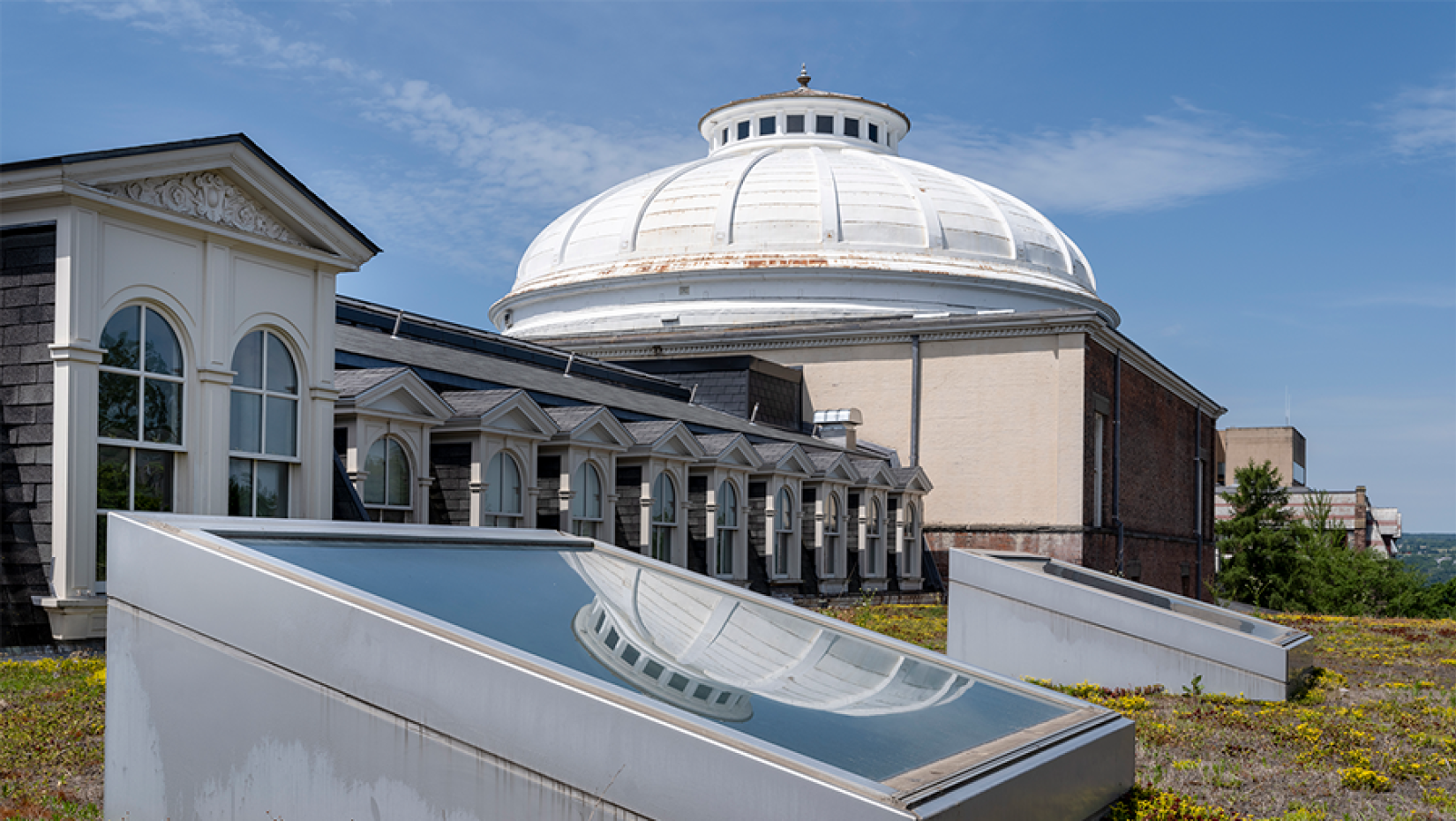 View of a white dome on top of a building viewed from an adjacent roof