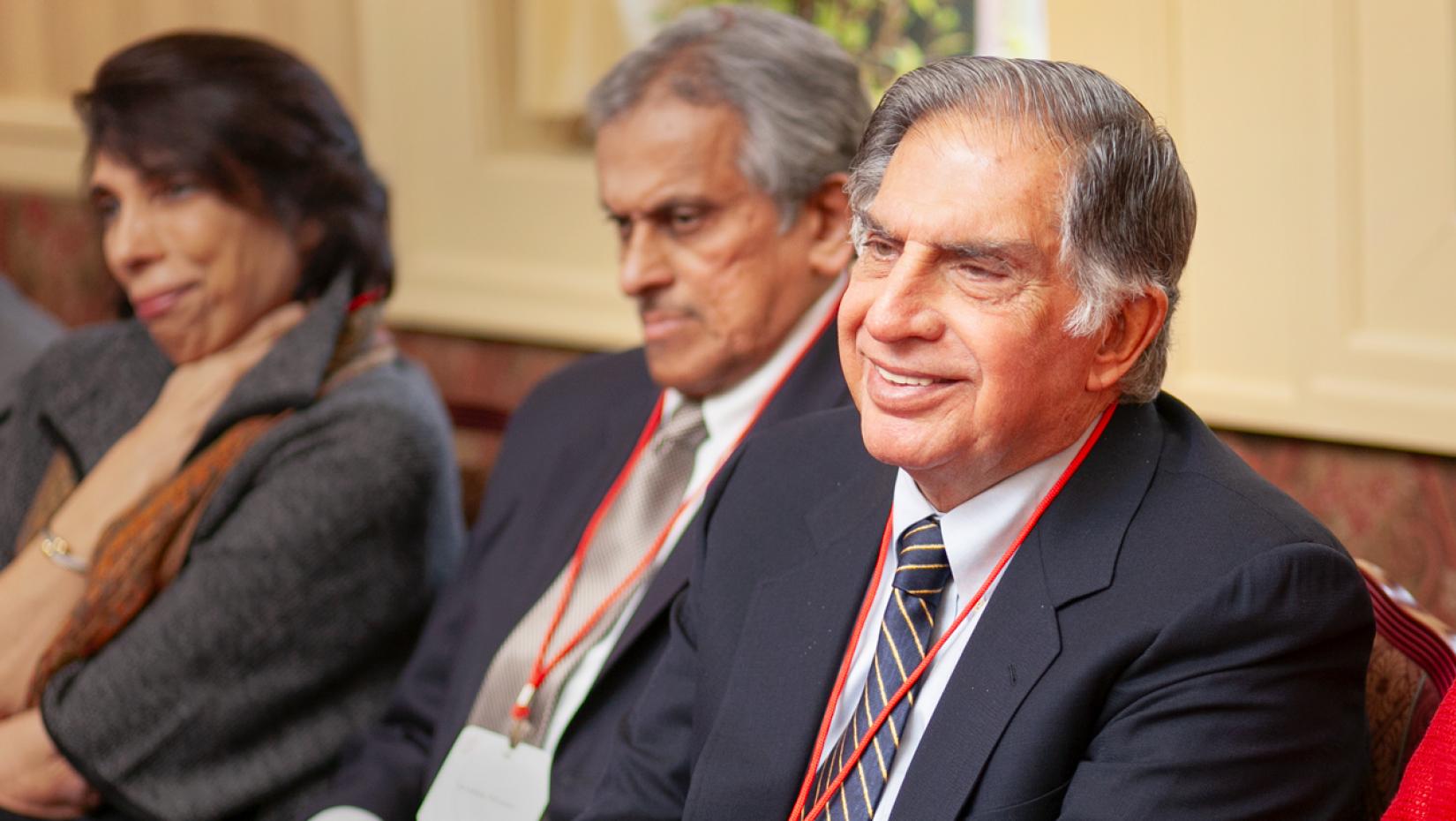 a person sitting at a table wearing a suit