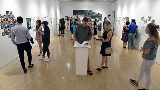 A crowd of student artists and their parents looks at work in an art gallery