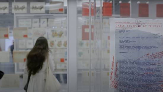 A person walking into a room with posters all over the walls.