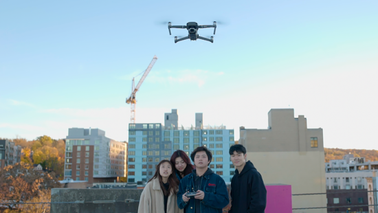 Group of students flying a drone on a rooftop