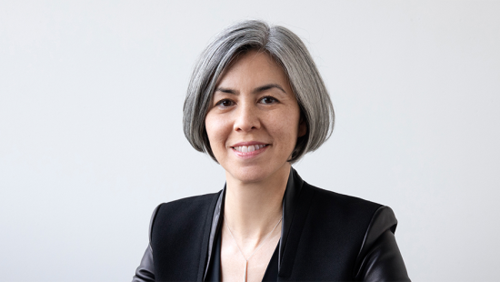 Woman with chin length silver hair wearing a black jacket