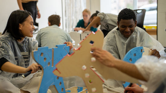students at a table working on cardboard construction