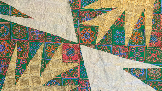 A colorful quilt with arrow-like patterns.
