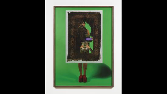 Person wearing red platform shoes against a green background in a wooden frame behind a cut out old carpet holding a vase.