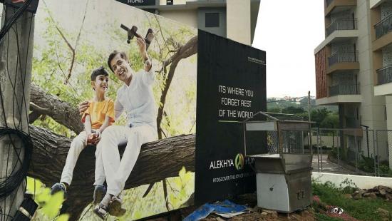 a large advertisement that shows a man and a boy sitting on a tree