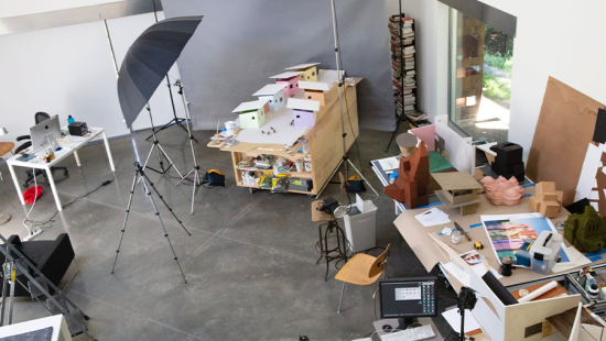 A space filled with photography lights and equipment, back drops, and architecture models.