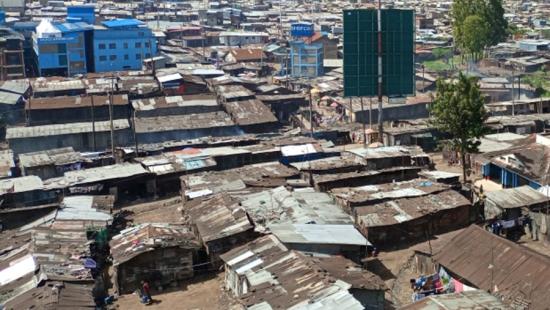 An aerial photograph of slums with a few modern building elements 