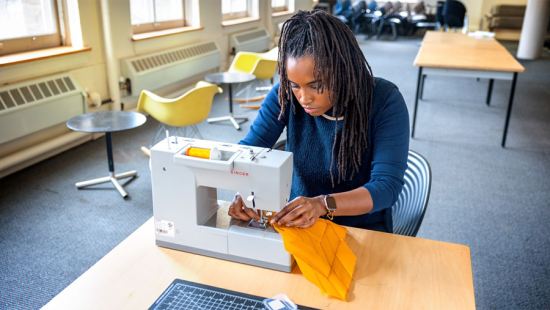 Woman working with bright yellow cloth at a sewing machine