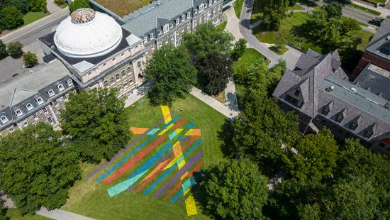 Aerial view of brightly painted geometric design on green grass